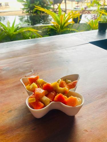 a bowl of food sitting on a table at Sea Shine Guest House in Hikkaduwa