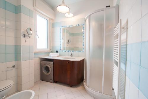 a bathroom with a sink and a washing machine at APPARTAMENTI SIVIGLIA in Cattolica
