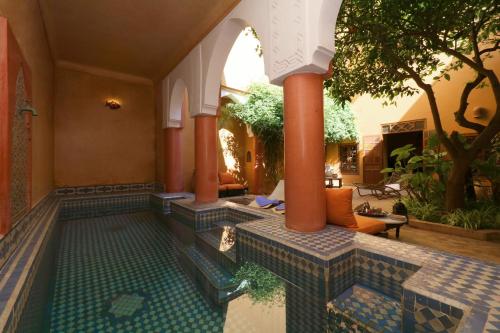 an indoor swimming pool in a house with a courtyard at Ryad El Borj in Marrakech
