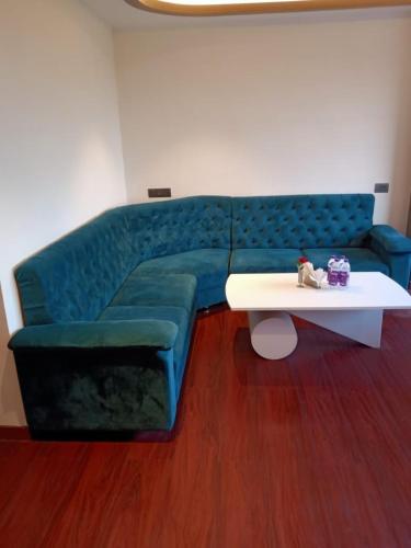 a living room with a blue couch and a table at The Emerald Hotel & Siya Milan Banquets in Muzaffarpur