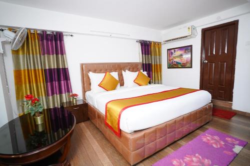 a bedroom with a large bed and a glass table at Hotel Brundavan Homes in Hyderabad