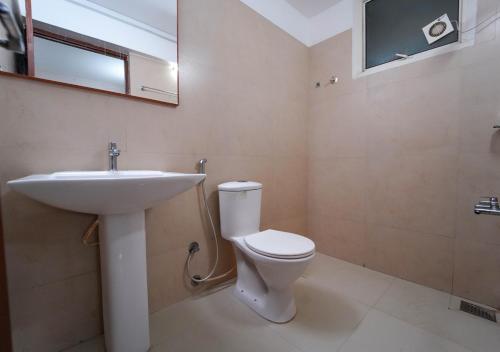 a bathroom with a white toilet and a sink at POP TAVERN Delight by VOYE HOMES in Veli