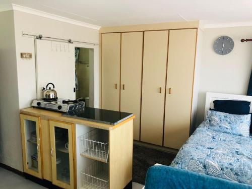 - une chambre avec un lit et une table avec une radio dans l'établissement Charming retreat in Danabaai, à Mossel Bay