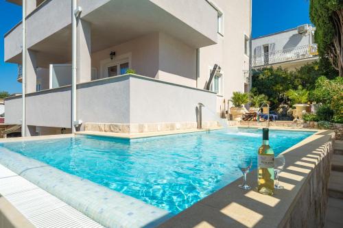 una piscina con una botella de vino junto a una casa en Apartments Villa Aura en Dubrovnik