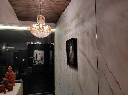 a hallway with a chandelier and a wall at The Beach House in Chennai