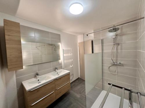 uma casa de banho com um lavatório e uma cabina de duche em vidro. em Gîte Les Gorges du Tarn em La Cresse