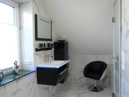 W łazience znajduje się umywalka, krzesło i lustro. w obiekcie Fewo direkt am See w mieście Dabel