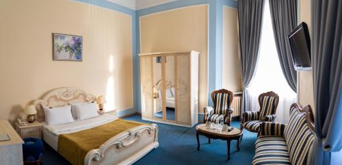 Pokój hotelowy z łóżkiem i krzesłem w obiekcie George Hotel w Lwowie