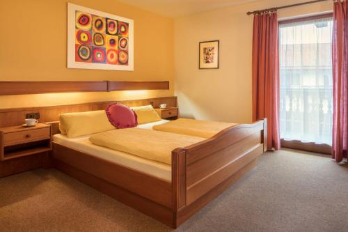 a bedroom with a bed and a window at Hotel zur Post in Büchlberg