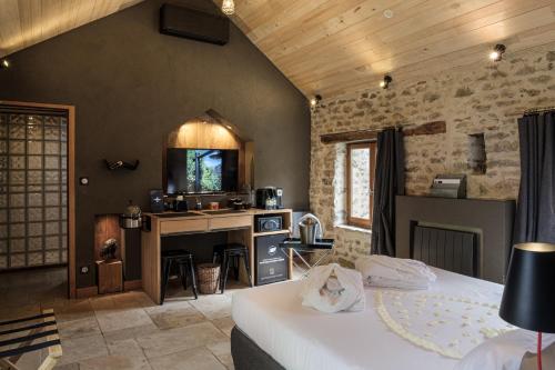 a bedroom with a bed and a desk in a room at Le Logis des Prés Verts Villa avec Jacuzzi Privatif in Jouey