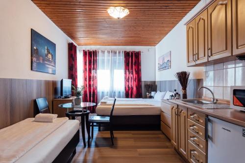 a room with two beds and a kitchen with a table at Hotel Hanseat Hamburg - Free Parking in Hamburg