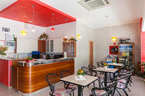a restaurant with tables and chairs and a counter at Hotel Sandra in Gatteo a Mare