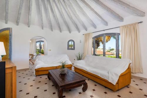 een slaapkamer met 2 bedden en een salontafel bij Villa Aloe - PlusHolidays in Calpe