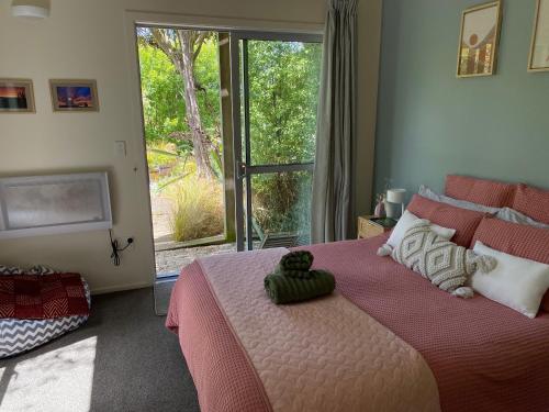 a bedroom with a large bed with a large window at The Willow Guest Suite in Dunedin