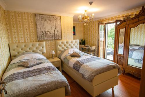 1 dormitorio con 2 camas y lámpara de araña en Gite les bons amis, en Plombières