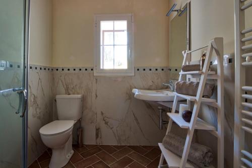 La salle de bains est pourvue de toilettes, d'un lavabo et d'une fenêtre. dans l'établissement Le Domaine Saint François La Tour 3, à Ajaccio