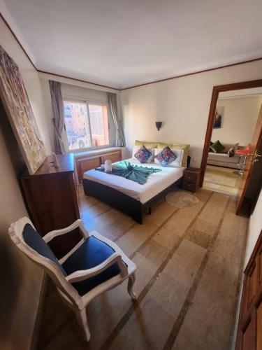 1 dormitorio con cama, silla y espejo en Appartement Patio centre Gueliz, en Marrakech