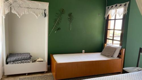um quarto com uma cama e uma parede verde em ACM Flat em Natal