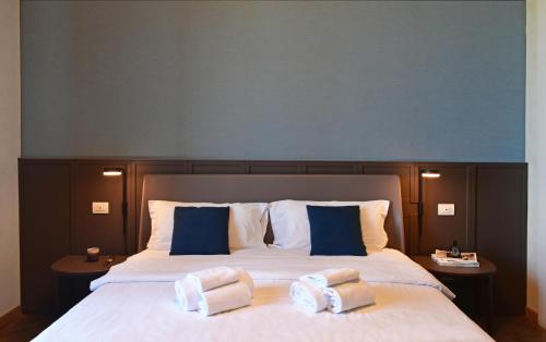 a bedroom with a large bed with blue and white pillows at Villa Pioppi Hotel in Sirmione