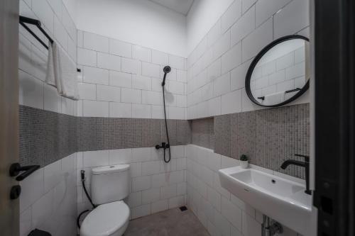 a bathroom with a toilet and a sink and a mirror at Cove River Haus in Jakarta