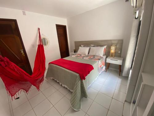 um quarto com uma cama com um cobertor vermelho em Charme Barra Mar em São Luís