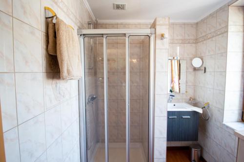 uma casa de banho com um chuveiro e um lavatório. em Gite les bons amis em Plombières