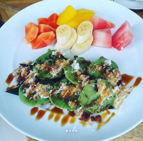 a white plate of food with fruit on it at Vin vin in Ubud