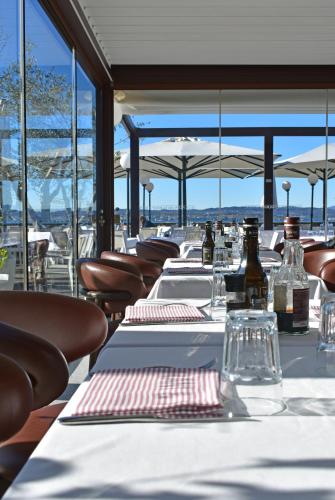 a row of tables with wine bottles and chairs at Villa Pioppi Hotel in Sirmione