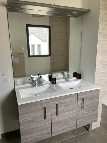 a bathroom with two sinks and a large mirror at Maison Bijou 3 chambres à 10min de DisneyLand Paris in Chalifert
