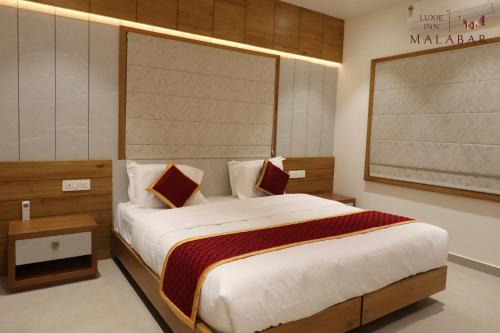 a bedroom with a large bed in a room at LUXIE INN MALABAR in Perintalmanna