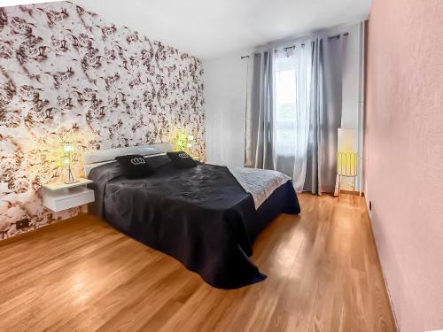 - une chambre avec un lit et un mur orné de fleurs dans l'établissement La Belle Époque d'Annecy, à Annecy
