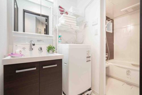 a white bathroom with a sink and a refrigerator at D墨田区民宿.晴空塔.浅草寺商圈.独栋别墅.直达机场、涩谷。新房源.小型室内停车位。 in Tokyo