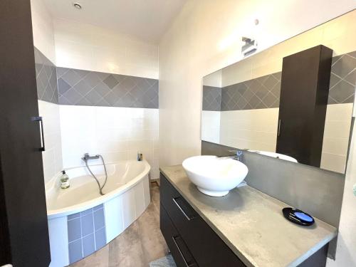 une salle de bain avec un lavabo et une baignoire et un lavabo dans l'établissement Appartement centre ville Cours Napoléon AJACCIO, à Ajaccio