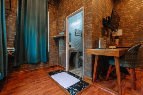 a room with a desk and a bathroom with brick walls at โอรีสอร์ต Oresort 