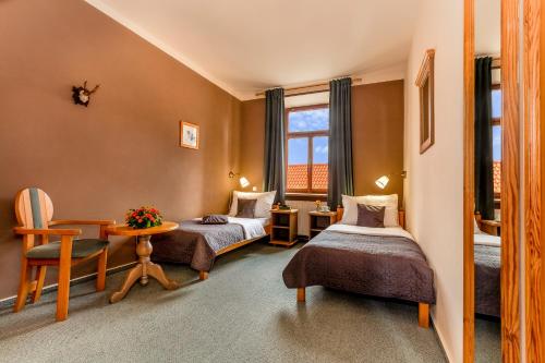 Zimmer mit 2 Betten und einem Tisch in der Unterkunft Hotel Panská in Bechyně