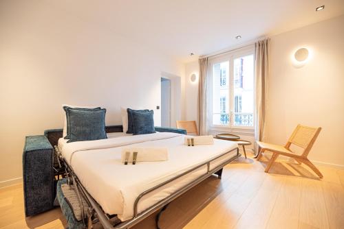 une chambre avec deux lits et une chaise dedans dans l'établissement Wonderful flat center of Paris, à Paris