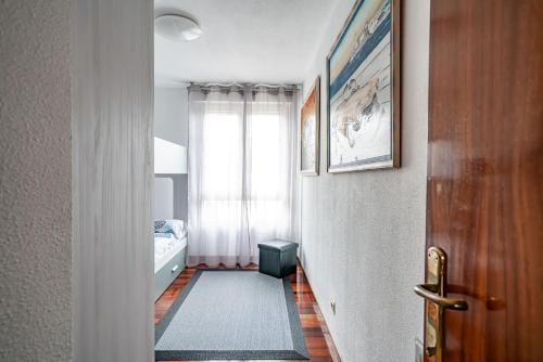 a hallway with a bedroom with a bed and a window at Piso con Piscina in Santander