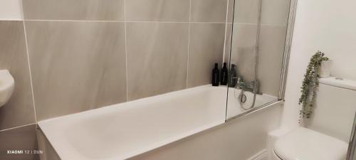 a white bath tub in a bathroom with a toilet at Glenmore Suites in London