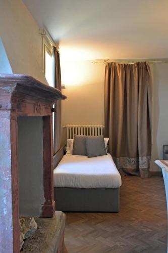 a bed sitting in a room with a fireplace at Villa Pioppi Hotel in Sirmione