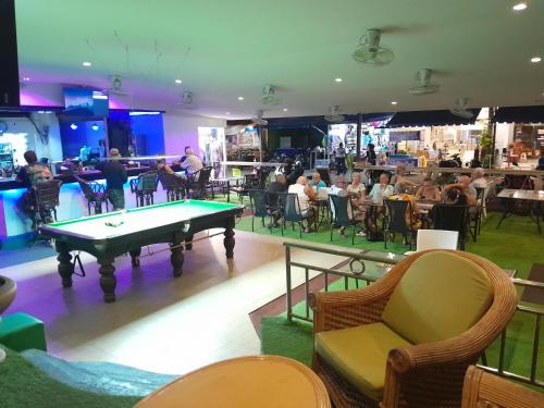 a pool table in a restaurant with people sitting in chairs at Oasis Guesthouse & Bar in Karon Beach