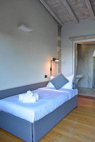 a bedroom with a large bed with white sheets at Villa Pioppi Hotel in Sirmione