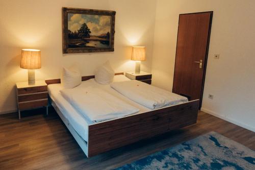 a bedroom with a large bed with two lamps at Gasthof Hotel zur Post in Egloffstein