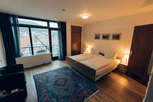 a bedroom with a bed and a large window at Gasthof Hotel zur Post in Egloffstein