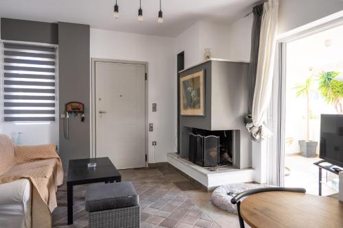 - un salon avec une cheminée et une table dans l'établissement Porto Rafti Hideaway, à Pórto Ráfti