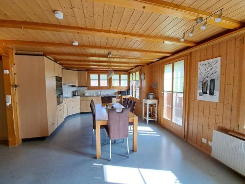 a kitchen with a wooden ceiling and a table and chairs at Family-friendly apartment with Alpine view in Matten
