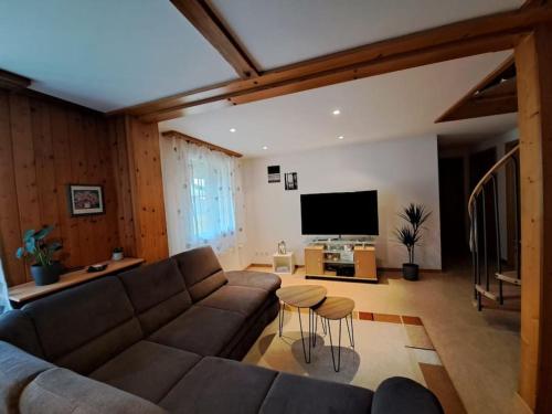 a living room with a couch and a flat screen tv at Family-friendly apartment with Alpine view in Matten