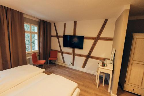 a hotel room with a bed and a flat screen tv at Gasthof Hotel zur Post in Egloffstein