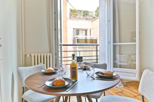 - une table avec des assiettes de nourriture et une bouteille de vin dans l'établissement Apparement à 5 minutes de Paris - Neuilly, à Neuilly-sur-Seine