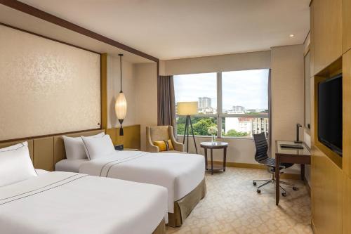 a hotel room with two beds and a television at Melia Hanoi in Hanoi
