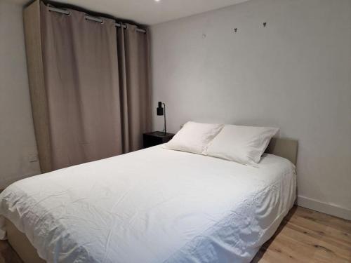 um quarto com uma cama branca e uma janela em Loft de charme hypercentre em Angers